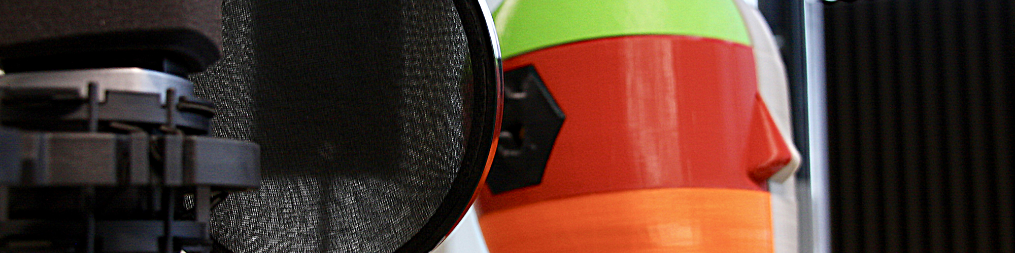 Close-up of professional studio microphone with colourful, 3D printed listening dummy behind