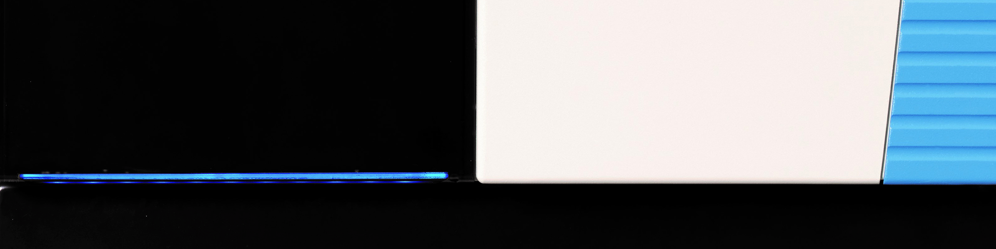 Abstract close-up of black, white, and blue panels above a dark base.