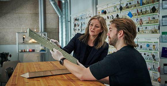 To personer samarbejder om et designprojekt i et innovativt miljø.
