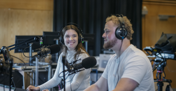 To studerende på Syddansk Universitet, der sidder i et podcaststudie