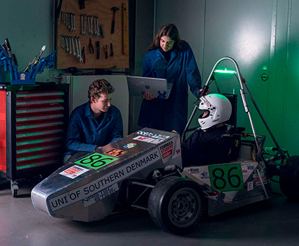 Studerende står ved sæbekassebil