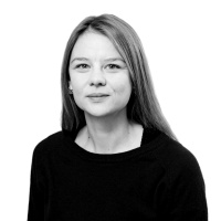 Sort-hvidt portræt af kvinde mod lys baggrund Sort-hvidt portræt af en kvinde med langt hår og mørk trøje mod lys baggrund.